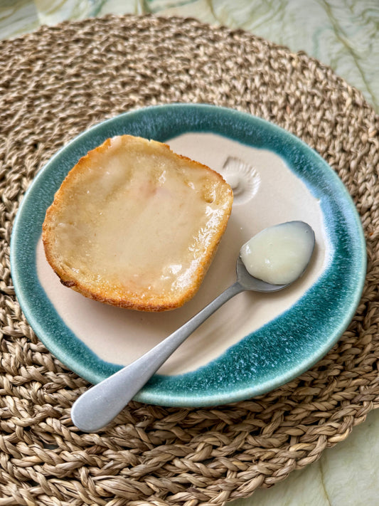 Golden toast topped with creamy raw honey, served with a spoonful of honey on a ceramic plate